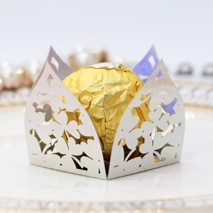 Macro view of laser-cut clover pattern on white iridescent candy box with chocolate