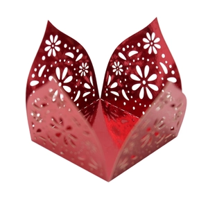 Close-up of laser-cut red metallic cupcake wrapper with intricate floral hollow patterns