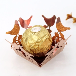 Detailed laser-cut bird and branch hollow candy box in metallic rose gold for weddings