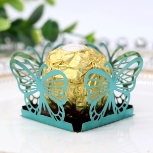 Detail of laser-cut butterfly candy box in cyan blue with a gold chocolate inside