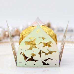 Close-up of laser-cut clover pattern on glossy light green candy box packaging