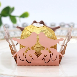 Macro shot of laser-cut pink bird pattern hollow candy box for wedding party favors