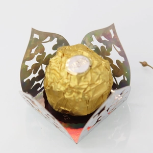 Macro view of laser-cut green holographic paper candy box with intricate floral patterns