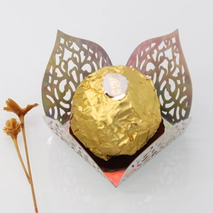 Macro detail of laser-cut iridescent floral candy box with metallic hollow pattern