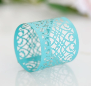 Detailed view of lake blue laser-cut napkin ring with ornate scrollwork on mirror surface