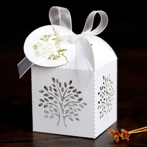 Detailed laser-cut tree design on a white gift box with silk ribbon and thank you tag