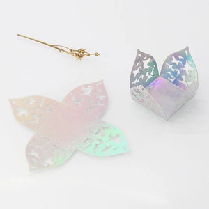 Macro view of laser-cut iridescent paper candy box showing detailed floral lace pattern