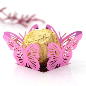 Close-up of laser-cut pink butterfly hollow candy holder with golden chocolate