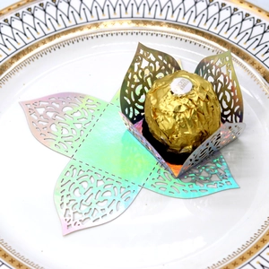 Detailed laser-cut holographic paper chocolate wrapper with floral lace patterns