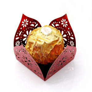 Detailed laser-cut dark red paper chocolate wrap with intricate star patterns and gold foil candy