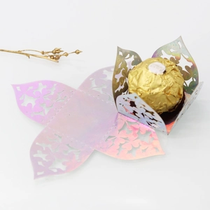 Detail of laser-cut iridescent hollow candy box with intricate heart and floral patterns