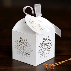 Close-up of laser-cut Tree of Life candy box with white ribbon and Thank You tag