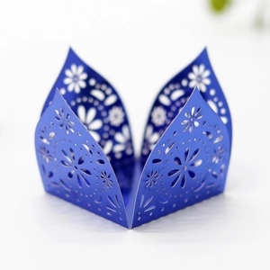 Detailed laser-cut floral patterns on navy blue pearlescent paper cupcake wrappers