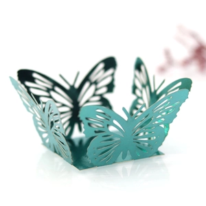 Intricate laser-cut butterfly cupcake wrapper in teal pearl paper for wedding decor