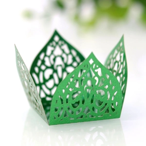 Close-up of green laser-cut crown pattern lace wrapper for cupcakes or candies