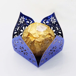 Detailed laser cut dark blue candy wrapper with daisy patterns and gold truffle
