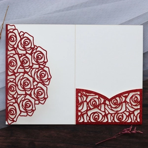 Detail of red glitter laser-cut rose wedding invitation with intricate floral cutouts