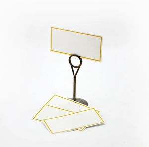 Close-up of vintage bronze metal table card holder with gold-rimmed blank place cards