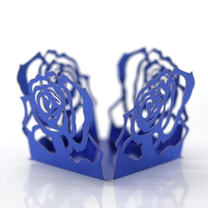 Détail du motif de rose découpé au laser bleu foncé sur boîte à bonbons de fête pliable