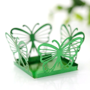 Detail showing green laser-cut paper candy box with intricate butterfly hollow carvings
