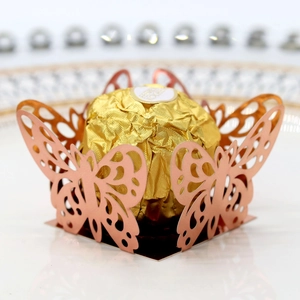 Macro detail of laser-cut rose gold butterfly candy box with intricate wing patterns