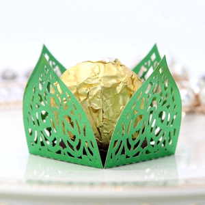 Macro view of laser-cut green lace paper chocolate wrapper with intricate floral patterns