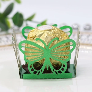 Detail of green butterfly paper candy box with intricate hollow cutouts for weddings