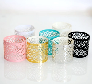 Detail of laser-cut heart pattern napkin rings in various metallic and pastel colors