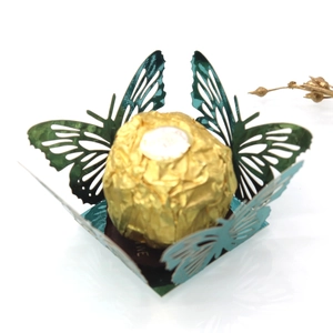 Macro detail of laser-cut green hollow butterfly decorative base for candies