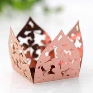 Detail of laser-cut rose gold crown favor box with hollow shamrock and flower patterns