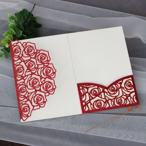 Macro detail of laser-cut rose bouquet pattern on red glitter wedding invitation cover