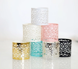 Macro view of various hollow laser-cut butterfly napkin rings in multiple metallic colors