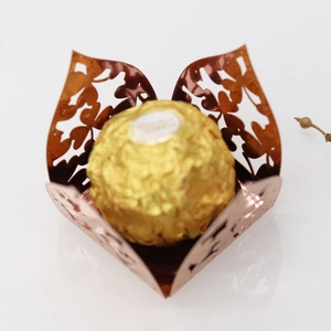 Macro detail of rose gold laser-cut clover candy holder with festive flower pattern