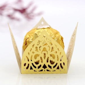 Close-up of laser-cut candy box with champagne gold lace pattern and chocolate