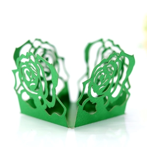 Détail d'une boîte à dragées verte découpée au laser avec motif de roses ajourées