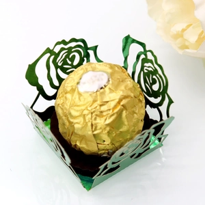 Détail de boîte à bonbons verte découpée au laser avec chocolat en feuille d'or