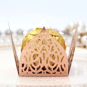 Macro view of rose gold laser-cut chocolate wrapper with elegant floral lace pattern