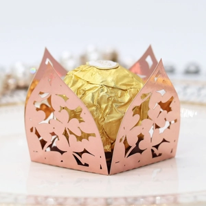 Macro shot of rose gold laser-cut candy box with intricate lace details and chocolate