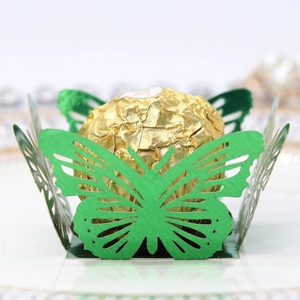 Macro shot of green butterfly laser cut candy cup with a chocolate for party decor