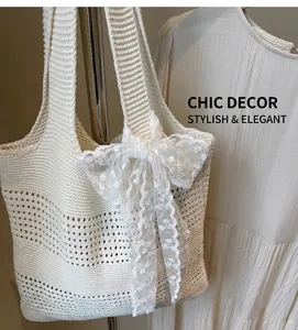 Détail d'un sac cabas en crochet blanc avec maille ajourée et nœud décoratif en dentelle