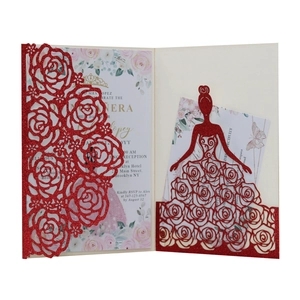 Close-up of laser-cut rose hollow pattern on red glitter invitation with floral inner card