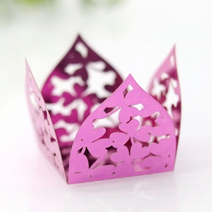 Macro detail of laser-cut pink hollow floral clover pattern candy box with metallic luster
