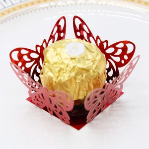 Macro detail of laser-cut red butterfly paper chocolate holder for wedding party decor