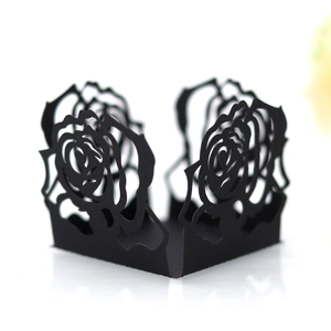 Détail de caissettes cupcakes noires découpées au laser avec motifs de roses ajourés
