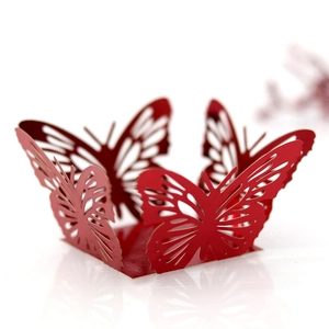 Detailed macro view of laser-cut red butterfly paper lace for wedding cake decoration