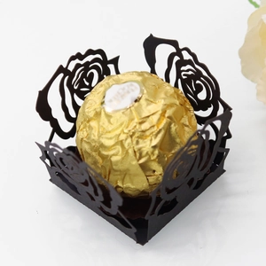 Détail de la boîte à bonbons ajourée noire découpée au laser avec chocolat doré