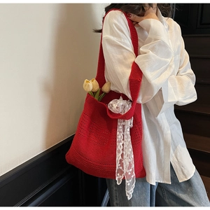 Détail du sac cabas rouge en tricot ajouré avec ruban de dentelle et tulipe