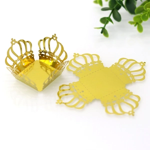 Macro detail of laser-cut gold crown cupcake wrapper in flat and folded states