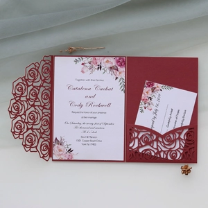 Detail of laser-cut burgundy rose wedding invitation set with floral printed insert card