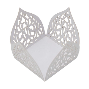 Detail of laser-cut white favor box with intricate hollow floral lace patterns